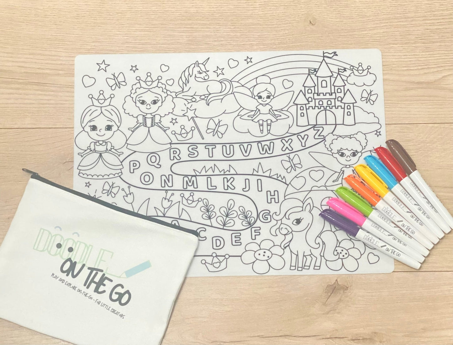 Coloring page with fairy tale characters and markers on a wooden surface