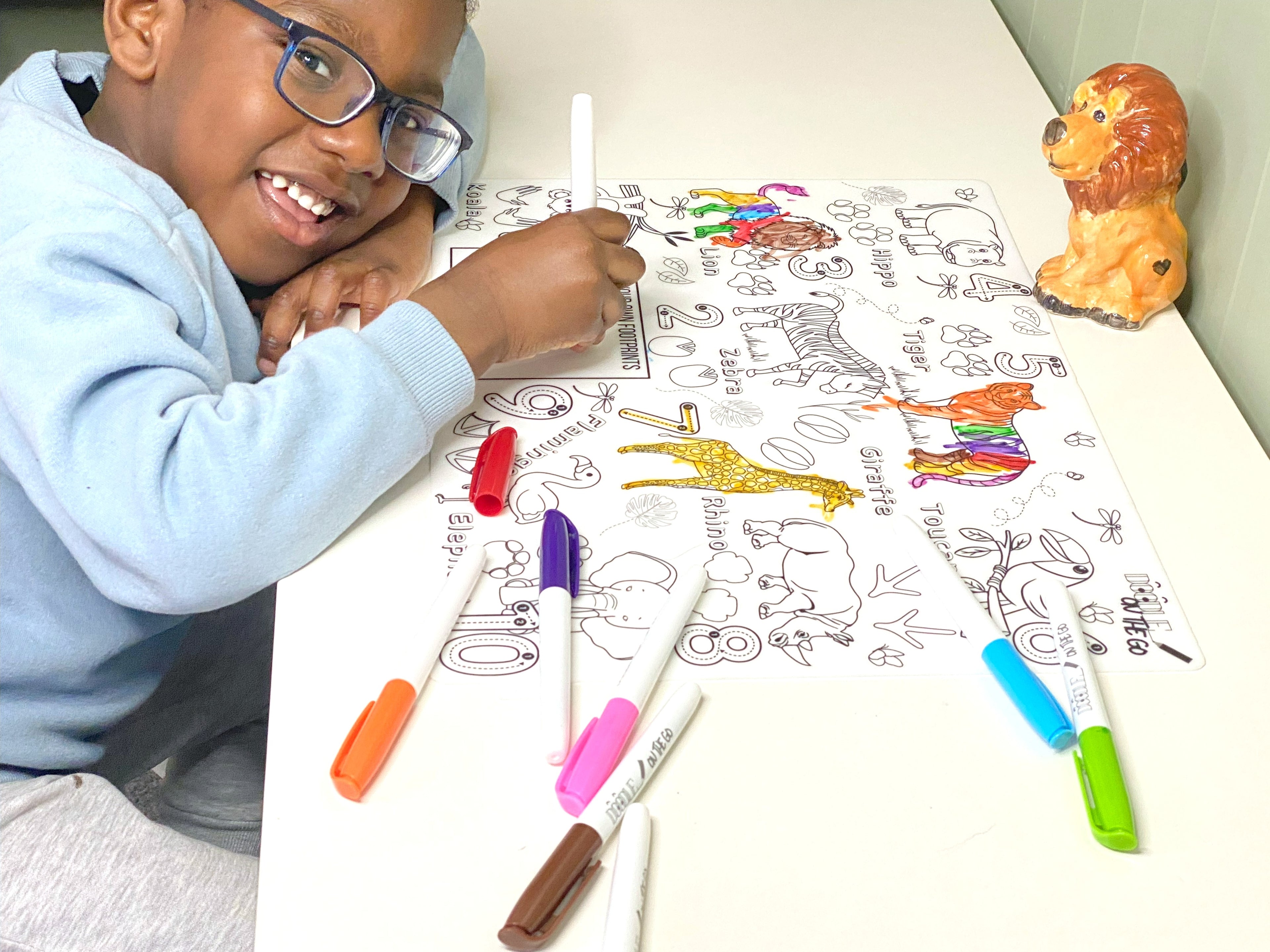 Child colouring on a reusable silicone mat with wipe-clean pens during creative play at home